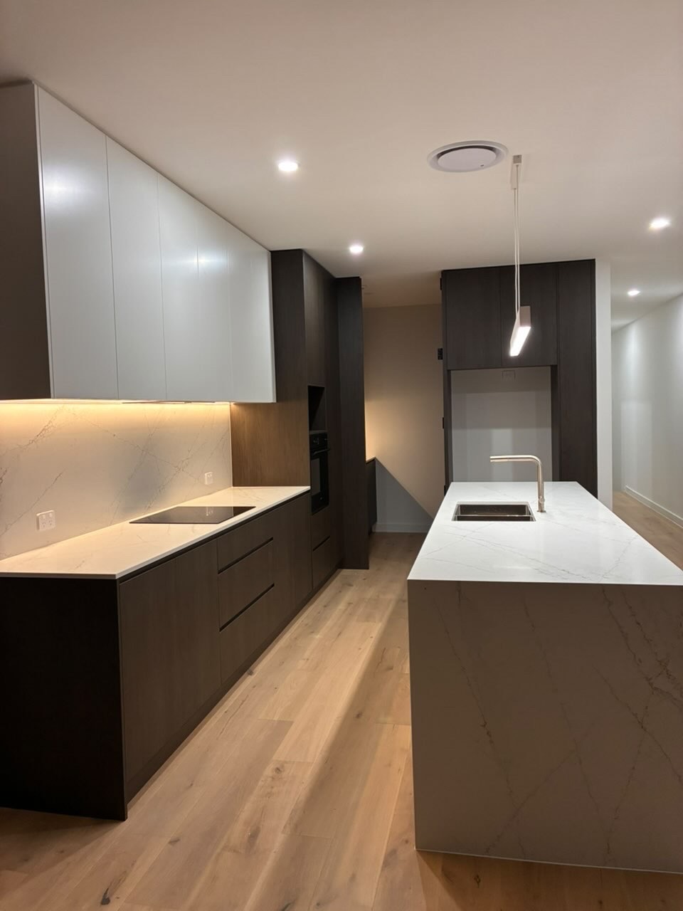 Detailed clean of a dark timber kitchen with marble island bench