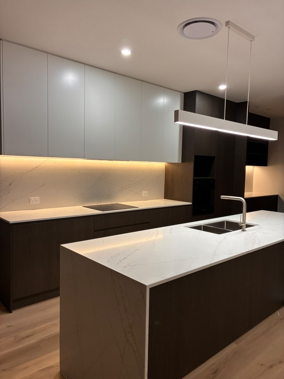 Spotless contemporary kitchen with marble island and under-cabinet lighting