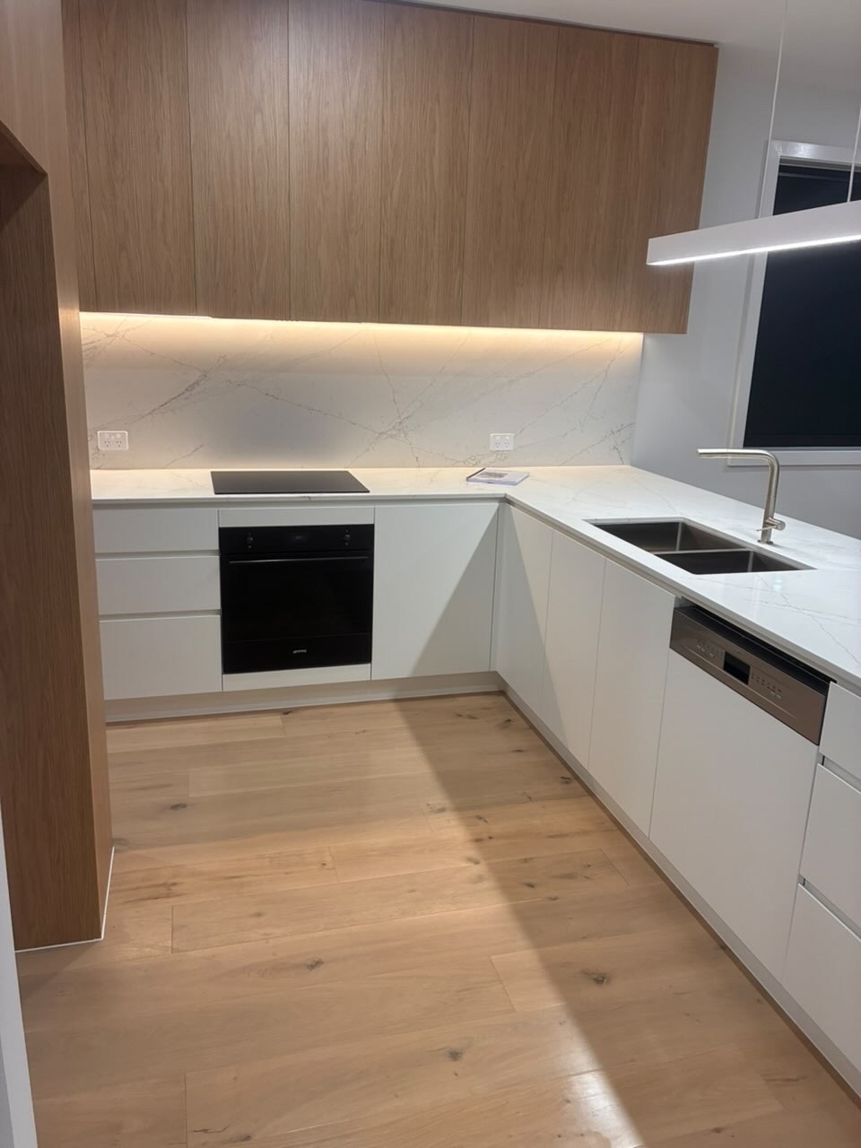 Sparkling L-shaped kitchen with marble splashback and timber cabinetry