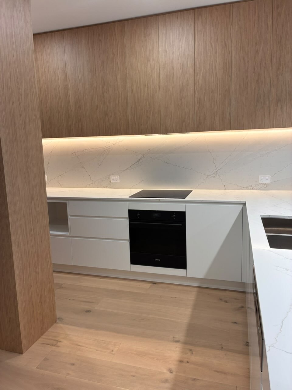 Modern timber kitchen with marble splashback and integrated appliances